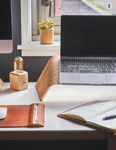 Mesa con portátil y cuaderno abierto con un bolígrafo y apuntes